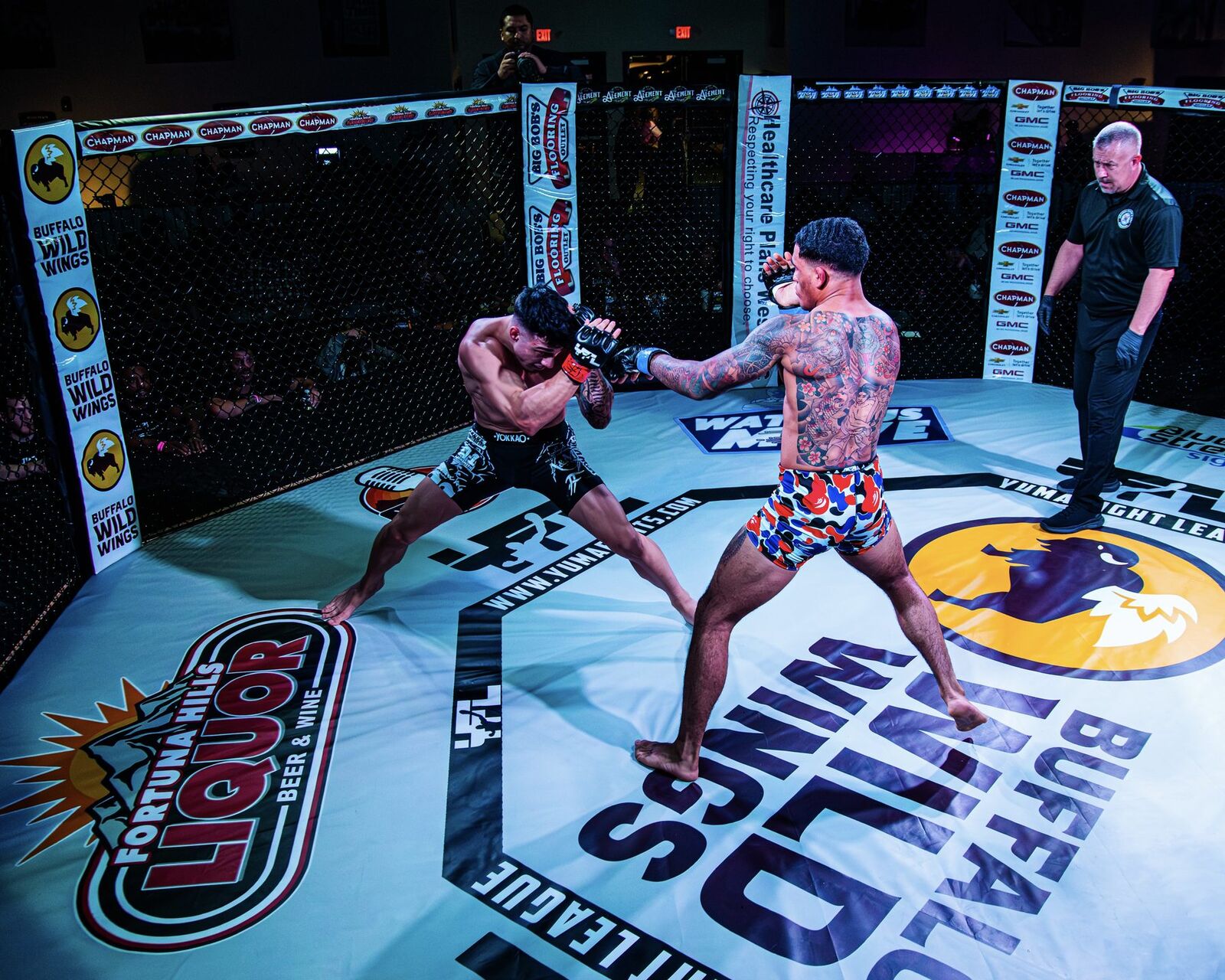YFL fighter throwing punch with Fortuna Hills Liquor and Buffalo Wild Wings banners in background
