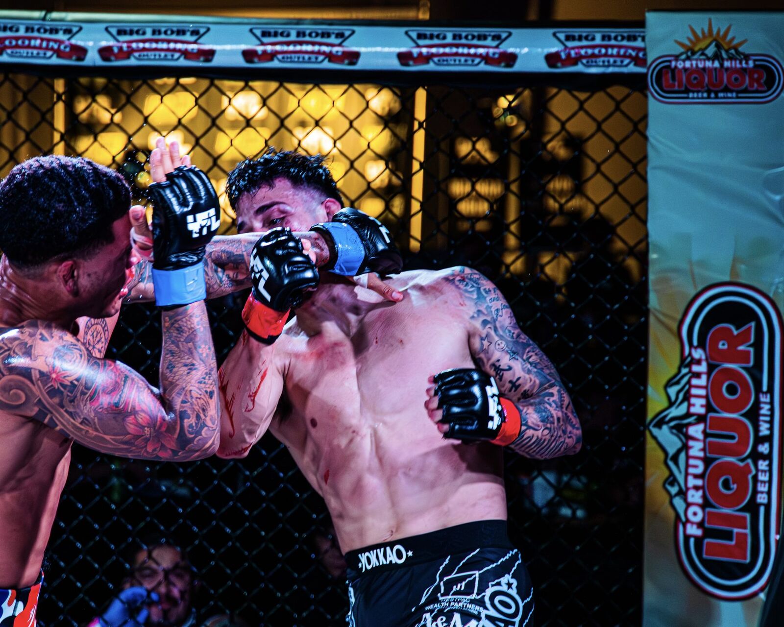 YFL fighters in close exchanges with Fortuna Hills Liquor banner prominently displayed